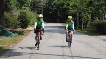 Len Bicknell and Laura Bicknell-Carbone ride their bikes side by side on a local road