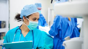 Anesthesiologist checking vital signs in OR