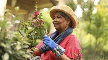 A Black woman outside working in her garden