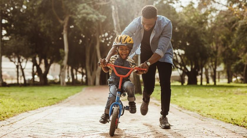 Dad helping son ride a bike