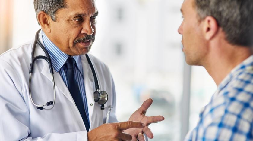A doctor consults with a middle aged male patient