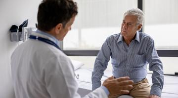 A doctor consults with a older male patient