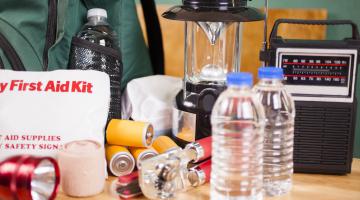 An emergency preparedness kit, featuring a radio, bottled water, a lantern, and other supplies.