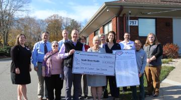 Employees from Gem Gravure of Hanover pose for a photo outside of 797 Main Street in Weymouth after making a $10,000 donation to South Shore Health.