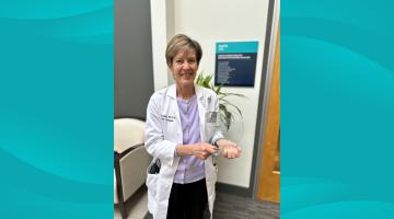 South Shore Health's Lisa Gould, MD, PhD poses for a photo holding a clear glass award.