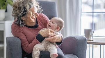 A grandmother holding her infant grandchild