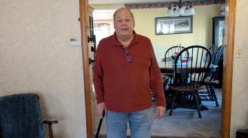 John of Rockland poses for a photo in his living room after an at-home outpatient rehab appointment.