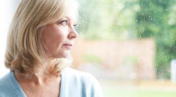 Woman looking out of a window at nature