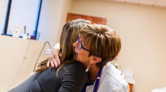 Midwife and mother hugging