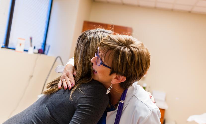Midwife and mother hugging