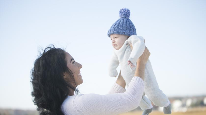 A mom holds a baby named Frank up in the air