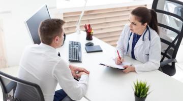 A young male patient consults with female provider at a desk