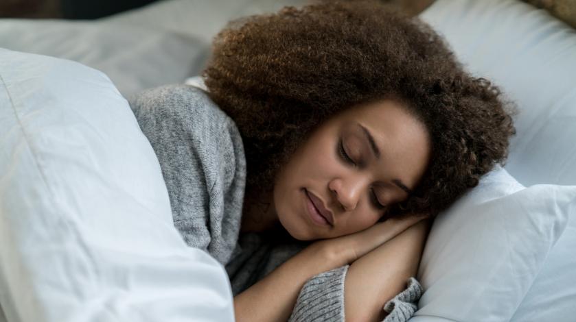 A young woman sleeps peacefully in bed